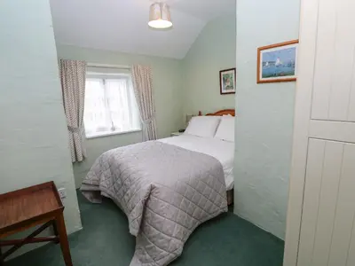 a bedroom with a bed and a window at Honeycrock in Cubert