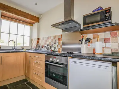 a kitchen with a stove and a sink at Wheal Honey in Newlyn East