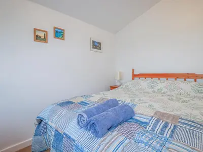 a bedroom with a bed with blue towels on it at The Annexe, Laburnum in Bugle