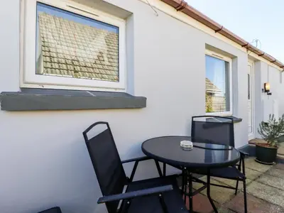 a patio with a table and chairs and a window at The Annexe, Laburnum in Bugle