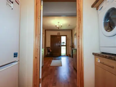 a hallway of a home with a washer and dryer at Summerfield Cottage in Gorran Haven