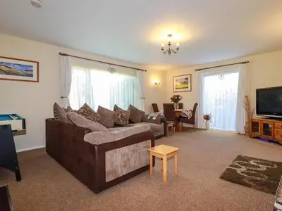 a living room with a couch and a television at Summerfield Cottage in Gorran Haven