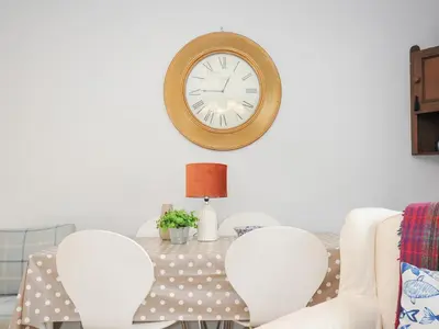 a dining room with a clock on the wall at No 1 The Heathers in Saint Cleer