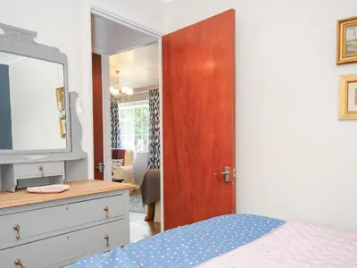 a bedroom with a bed and a dresser with a television at No 1 The Heathers in Saint Cleer