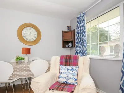 a living room with a couch and a clock on the wall at No 1 The Heathers in Saint Cleer