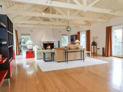 a living room with a couch and a fireplace at Penarvon House in Helford