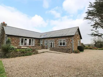 an old stone house with a gravel driveway at Penarvon House in Helford