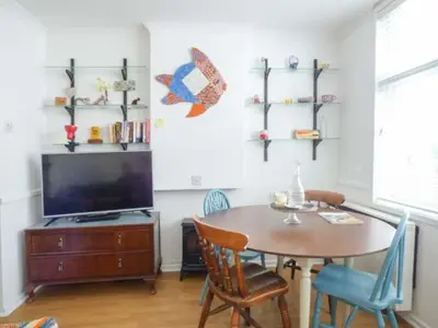 a dining room with a table and a television at Tidewood in Polzeath