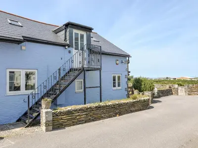 a blue house with a staircase on the side of it at The Blue House in Tintagel