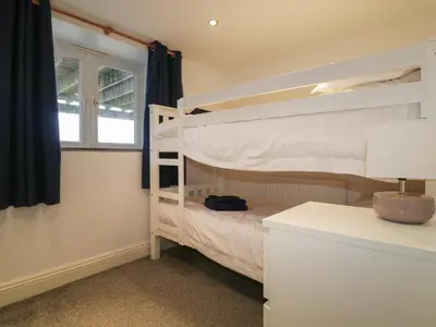 a bedroom with a bunk bed and a desk at The Blue House in Tintagel