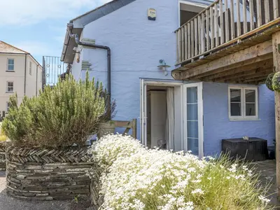a blue house with white flowers in front of it at The Blue House in Tintagel