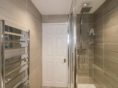a bathroom with a shower and a white door at Tremanners in St. Agnes