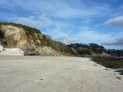 a sandy beach next to a rocky cliff at 28 Clock Tower Court in Charlestown