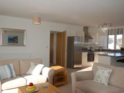 a living room with two couches and a kitchen at 28 Clock Tower Court in Charlestown