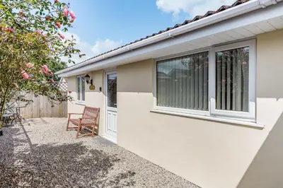 a house with a window and a chair at 19 Cormorant Drive The Annexe in St Austell