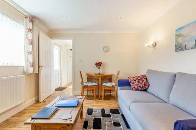 a living room with a couch and a table at 19 Cormorant Drive The Annexe in St Austell