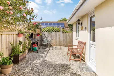 a patio with a table and chairs next to a fence at 19 Cormorant Drive The Annexe in St Austell
