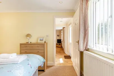 a bedroom with a bed and a dresser and a window at 19 Cormorant Drive The Annexe in St Austell
