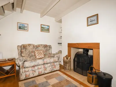a living room with a couch and a fireplace at The Ark Cottage in Par