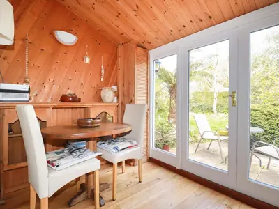 a dining room with a table and chairs and a patio at The Ark Cottage in Par