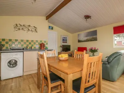 a kitchen and dining room with a table and chairs at Tiggy Winkle in St Merryn