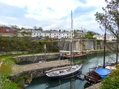 two boats are docked at a dock in the water at Tehidy in Charlestown
