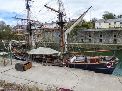 a boat is docked at a dock in the water at Tehidy in Charlestown