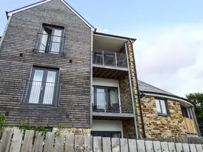a brick house with a fence in front of it at Tehidy in Charlestown