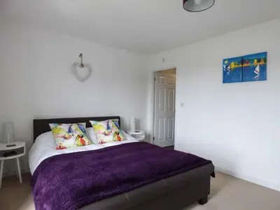 a bedroom with a bed with a purple blanket at Tehidy in Charlestown