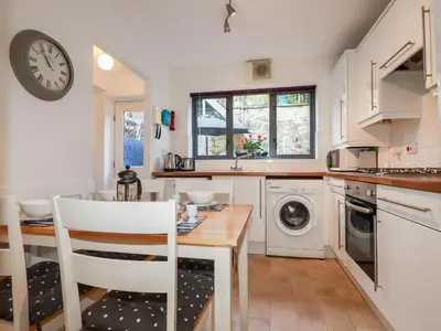 a kitchen with a table and a clock on the wall at The Mackerel in Charlestown