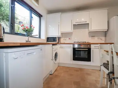 a kitchen with white cabinets and a sink and a dishwasher at The Mackerel in Charlestown