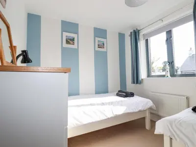 a bedroom with blue and white striped walls at The Mackerel in Charlestown