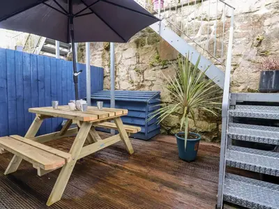 a picnic table with an umbrella on a patio at The Mackerel in Charlestown