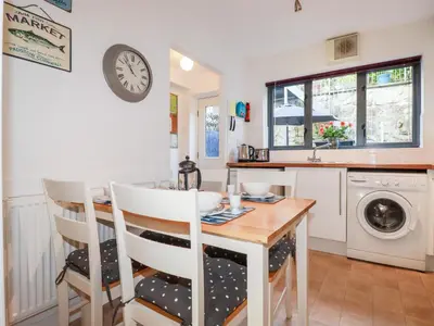 a kitchen with a table and chairs and a clock on the wall at The Mackerel in Charlestown