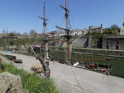 a boat is docked in the water next to a dock at The Mackerel in Charlestown