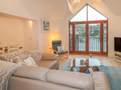 a living room with a couch and a table at The Creekside in Looe