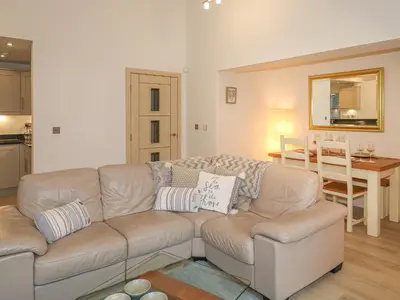 a living room with a couch and a table at The Creekside in Looe