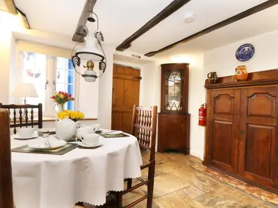 a dining room with a table and a chandelier at 13 Castle Hill in Lostwithiel