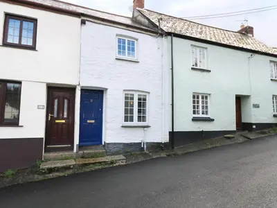 a row of white houses with blue doors on a street at 13 Castle Hill in Lostwithiel