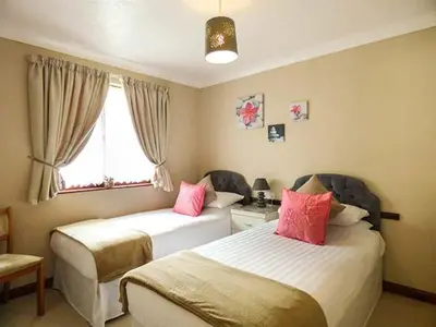 a bedroom with two beds with pink pillows at Chy Lowenna in Saint Cleer