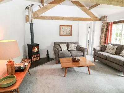 a living room with a couch and a fireplace at Treverbyn Smithy in Saint Neot