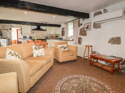 a living room with two couches and a table at Foxes in Lanivet