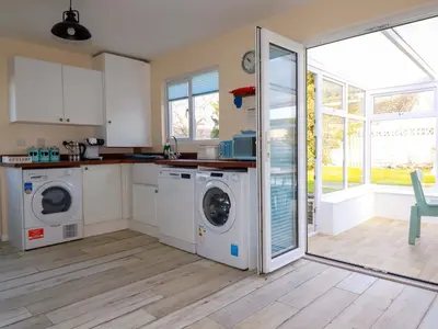 a kitchen with two washing machines and a counter at Merlin's Retreat in Tintagel