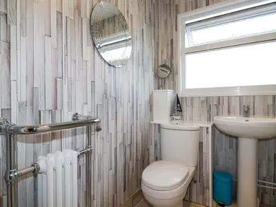 a bathroom with a toilet and a sink and a mirror at Merlin's Retreat in Tintagel