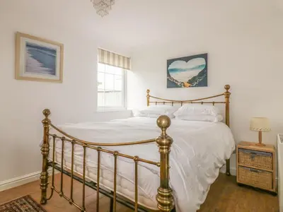 a bedroom with a large bed with white sheets at Apartment 1, Trearren in St. Agnes