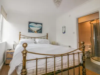 a bedroom with a bed and a shower at Apartment 1, Trearren in St. Agnes