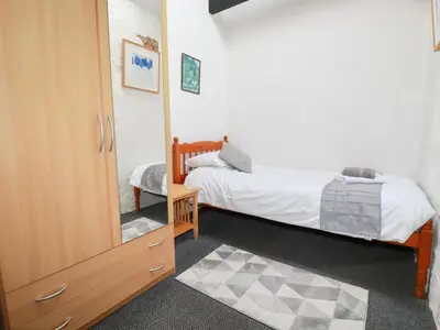 a bedroom with two beds and a mirror at Badgers Sett in Lanivet