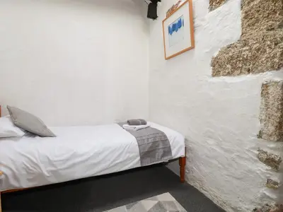 a bedroom with a bed in a white wall at Badgers Sett in Lanivet