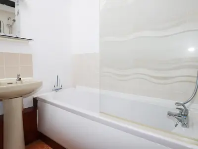 a white bathroom with a tub and a sink at Badgers Sett in Lanivet