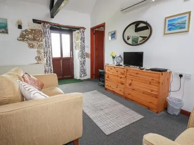 a living room with a couch and a television at Badgers Sett in Lanivet